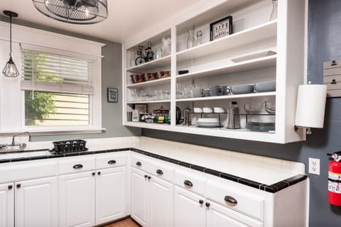 The kitchen is equipped with plenty of dishes and cookware, as well as a traditional drip coffee maker and Keurig.