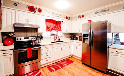 Modern Charm: A Bright and Welcoming Kitchen Accented with Vibrant Red Curtains and Mat 🍽️🔴