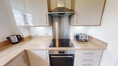 Modern kitchen with electric hob, oven, dishwasher and wahsing machine.