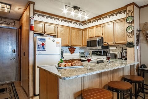 The kitchen features a newly installed (2024) granite countertops with bar seating.