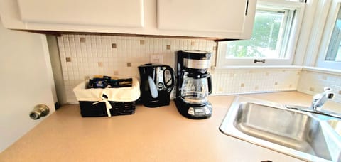 Coffee maker, kettle and complimentary coffee, creamer and sugar with snacks