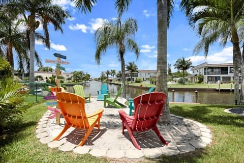 Relax by the canal with colorful Adirondack chairs and scenic palm views.