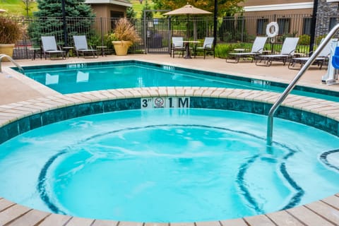 Hot tub with jets surrounded by lounge chairs.