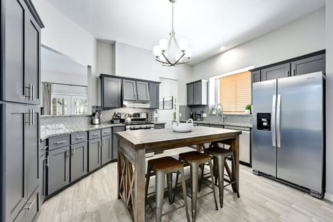 Fully equipped kitchen at Silverwood with gas range, stainless appliances, and island seating—perfect for cooking before a night at The Domain.