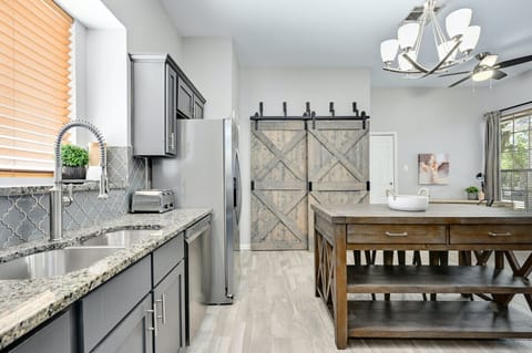 Stylish Silverwood kitchen with granite counters, farmhouse barn doors, and large island for meal prep or casual breakfasts.