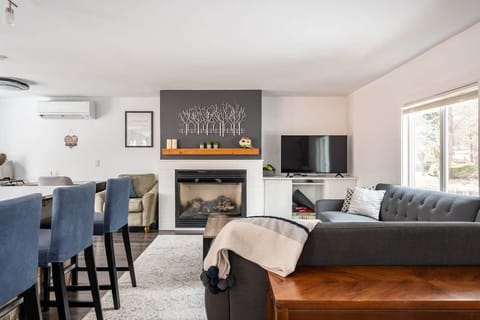 Living room with gas stove, L-shaped, couch, coffee table and 50” Roku tv. 