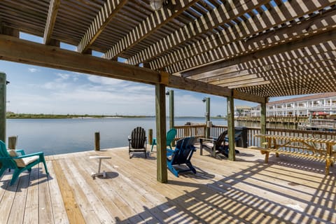 Relax in comfort on your private waterfront deck, where colorful Adirondack chairs await beneath the shaded pergola overlooking serene waters.