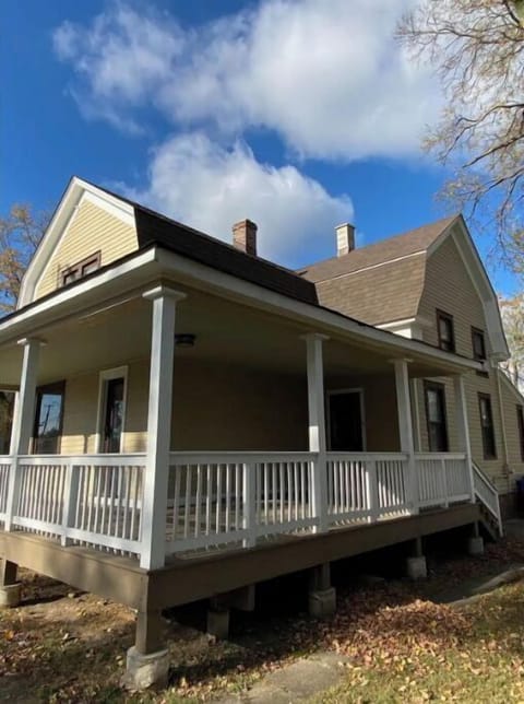Main house with porch. Nice wicker furniture on porch, but street is busy.