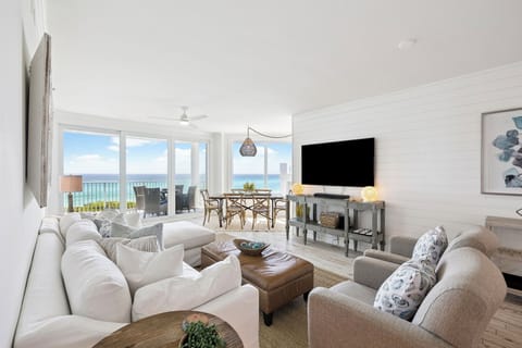 Relax in your bright coastal living space where ocean views stretch endlessly beyond floor-to-ceiling windows.