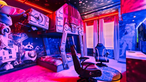 Epic space-themed room with AT-AT bunk beds, gaming chairs, and galactic decor!