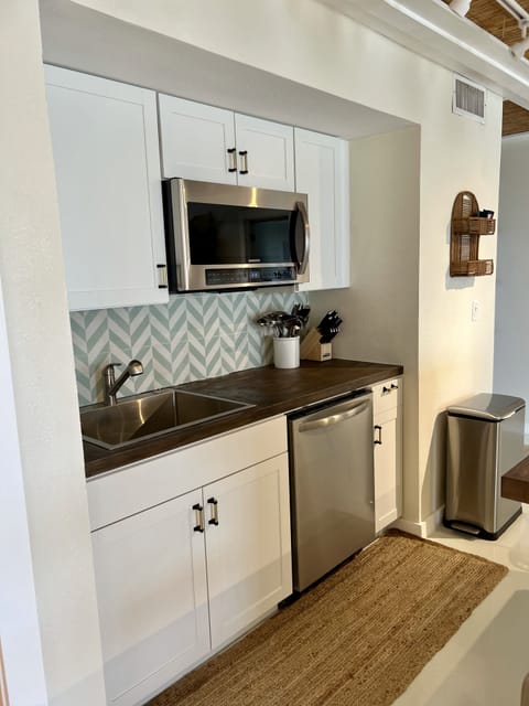 Kitchen with dishwasher and microwave. Electric Ninja air fryer and cooktop. 