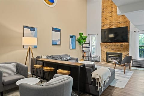 View of living area with decorative fireplace and TV