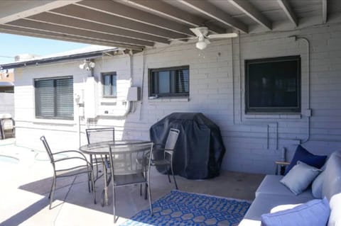 Covered back patio with outdoor furniture and BBQ.