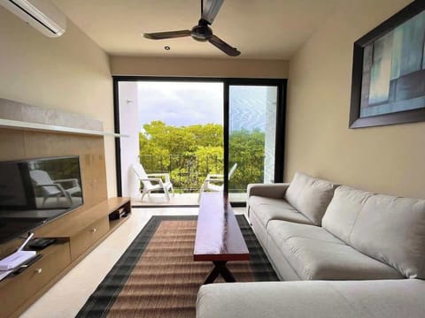 Living room with sofa, smart TV, ceiling fan and balcony
