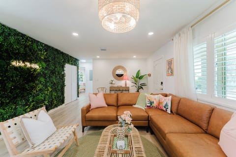 Unwind in the bright, professionally designed living room featuring comfortable seating, a large Smart TV, and beautiful tropical-inspired décor.