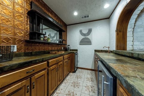 Off the hallway is a wet bar area, equipped with a sink, ice maker, wine fridge, and drink prep area. The bar has plenty of space for guests to make all their favorite cocktails.
| 9T Ranch by Boutiq Luxury Vacation Rentals | Gonzales, Texas