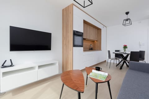 A modern TV and media unit, with adjacent open-concept living and dining areas.