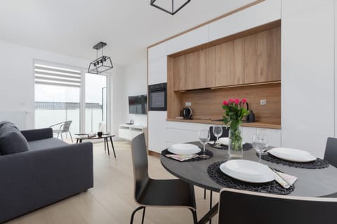 A close-up of a round coffee table with decorative items, set against a bright living area.