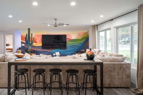 Large living room with a sit up sofa bar and beautiful desert murals that brings the indoors into the home.