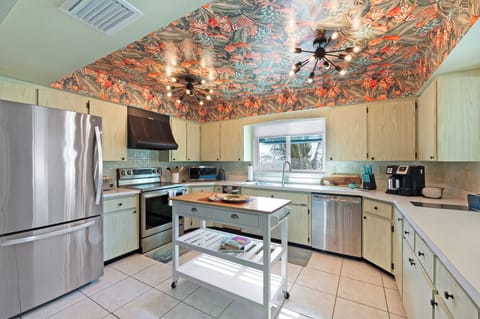 Your tropical kitchen features bold ceiling art and modern amenities, creating an inspiring culinary space with gulf views.