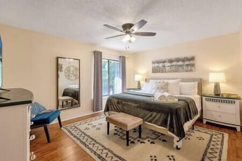 The primary bedroom boasts a King-size bed, full-size mirror, and seating area.