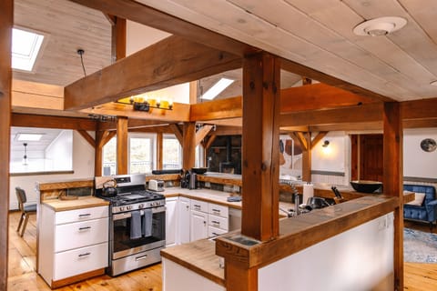 Main level kitchen is an open concept encapsulated in  huge rustic wood beams
