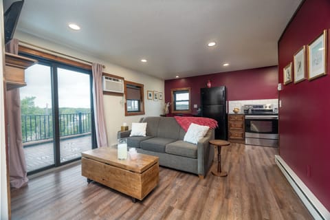 Open-concept comfort meets thoughtful design: a plush sofa, electric fireplace, and smart TV with streaming apps await. Balcony views and natural light flood this stylish second-floor living room. Guests rave about the vibe—“cozy, clean, and well-furnished
