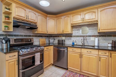- Bright and welcoming kitchen with updated lighting and a sleek undermount sink
- Open shelving with decorative plants adds a cozy, homey touch
- Dishwasher and elegant finishes ensure a comfortable and effortless cooking experience