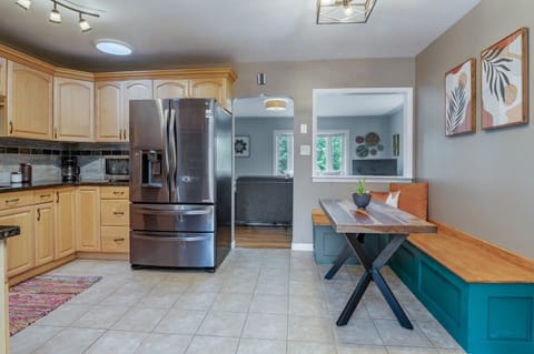 - Fully equipped kitchen featuring modern stainless steel appliances and counter space
- Breakfast nook with vibrant cushions and a live edge wood table
- Natural light and contemporary décor create a warm and inviting space to start your day