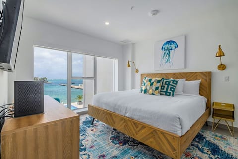 Drift off in your bright bedroom with stunning ocean views—turquoise water just beyond the balcony, crisp linens, and coastal touches that make every morning feel like paradise.