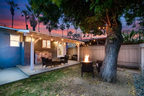 Enchanting outdoor patio at sunset with cozy seating, string lights, and a shaded area, perfect for evening relaxation and social gatherings.