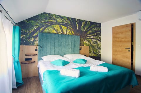 King-sized bed, towels included, nature wallpaper.