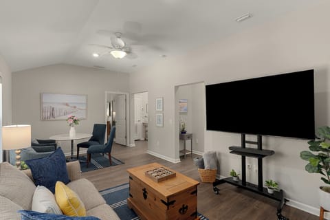 Bright living area with coastal decor, dining nook, games, and a large TV for easy downtime.
