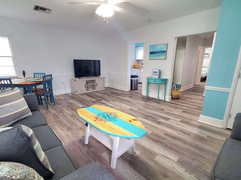 Large living room with dining table, Large 55" TV. Hallway brings you to bathroom and bedroom. Closet on the right is packed with amenities including all your beach essentials, beach chairs, beach umbrellas, towels, cooler and much more!