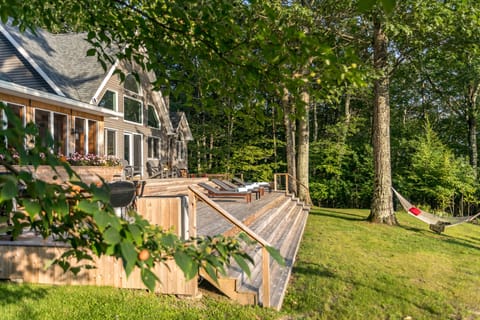 1,800 sq ft deck, outdoor dining table, hot tub and hammock facing the mountains
