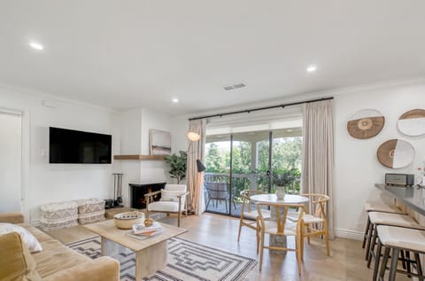 Enjoy the cozy ambience of the fireplace and easy access to the balcony in the condo’s living room.