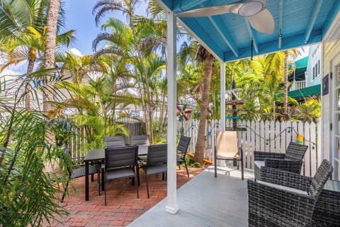 The back patio boasts an outdoor dining area, additional seating, and string lights.