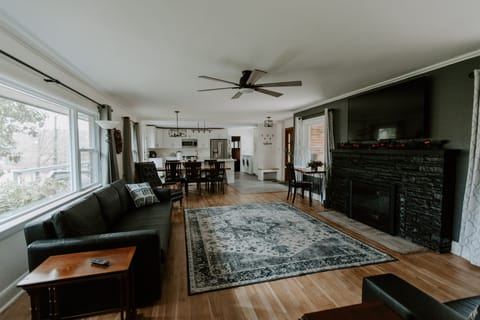 Living room has gas fireplace, 65" TV and ceiling fan.
