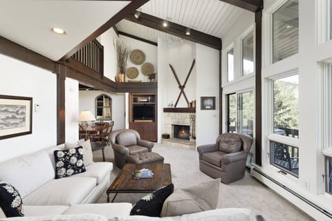 The living room features a flat screen TV, wood burning fireplace and access to the balcony with a gas grill.