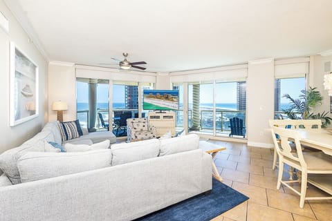Relax in your bright living space with panoramic ocean views through floor-to-ceiling windows, where coastal breezes and endless blue horizons create your perfect beachside retreat.