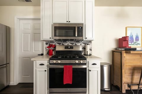 Kitchen with stove, microwave, and stocked coffee bar