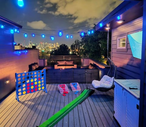 Roof deck furniture set with gas fire pit and amazing skyline views. Roof deck has a day bed, 55` TV, swing chair, and putt golf game
