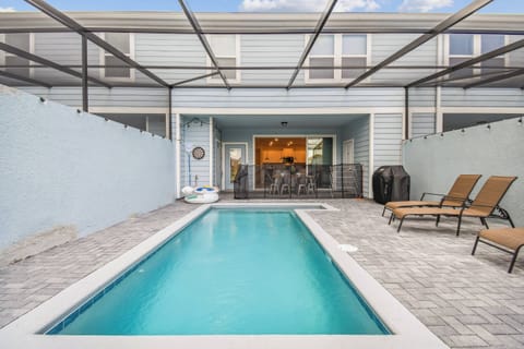 Step outside to your private oasis, where a shimmering pool invites you to unwind. The sleek paver stones create a stylish backdrop, complemented by comfortable loungers, perfect for soaking up the sun in a relaxed atmosphere.