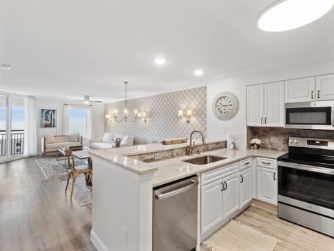 Your elegant kitchen flows seamlessly into the living space, featuring granite countertops and stainless appliances perfect for preparing meals.