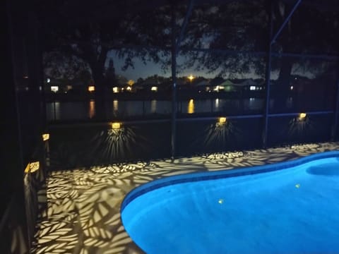 Lights reflecting off the lake poolside at night.