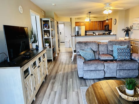 Sink into plush seating while enjoying your favorite shows on the large TV in this inviting open-concept space with modern kitchen.