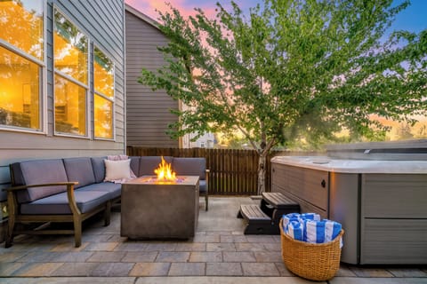 Unwind in the private outdoor retreat with a steaming hot tub, fire table, and cozy lounge seating.