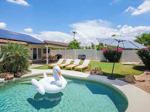 Backyard featuring pool, putting green, and outside dining area.