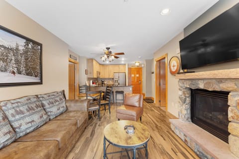 Relax in your cozy mountain retreat with a stone fireplace warming the open living space, modern kitchen, and rustic furnishings.
