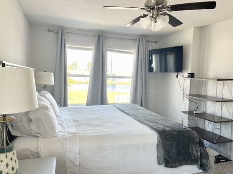 Master bed with king size bed , office desk , walk in closet with pool views 
